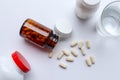 Flat lay of Vitamins, Pills are poured out from the brown glass bottle on white background Royalty Free Stock Photo