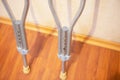 Medical and Health Concept. Pair of Crutches for Disabled People Placed Against Wall Indoors