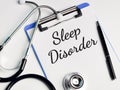 Phrase SLEEP DISORDER written on paper clipboard with stethoscope and a pen.