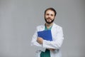 Medical Internship. Portrait Of Happy Male Doctor Student In Uniform Holding Clipboard In Hands And Posing Over Light Background Royalty Free Stock Photo