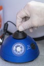 Medical lab scientists in laboratory using Vortex Mixer to mix a solution in a Reaction vessel.