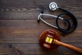 Medical law, health law concept. Gavel and stethoscope on dark wooden backgound top view copy space