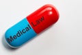 Medical Law stands on a blue and red large medical pill that has been isolated against a white background with space for text