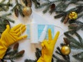 Medical mask with antiseptic, hands in yellow gloves showing a sign that everything will be fine, surrounded by fir branches on a