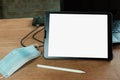 Medical mask and Digital tablet white blank screen display . Royalty Free Stock Photo