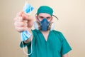 Doctor holds medical mask on the yellow background defocused