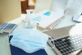 Medical mask and hand disinfectant on table in home office Royalty Free Stock Photo