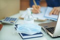Medical mask and hand disinfectant on table in home office Royalty Free Stock Photo