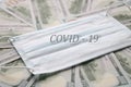 Medical mask with the inscription COVID - 19 on the money bills. Economy and virus concept Royalty Free Stock Photo