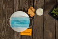 Medical mask lies on a white plate with milk and cookies on the table and next to the words good morning in English Royalty Free Stock Photo