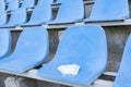 A medical mask is lying on a stadium chair. Empty stands.Protection of the crown from viruses and bacteria ceases. Royalty Free Stock Photo