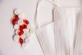Medical mask and tablets with capsules on a white background. Royalty Free Stock Photo