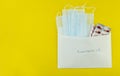 medical masks and tablets in a white envelope on a yellow background, isolates, Royalty Free Stock Photo