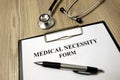 Medical necessity form with pen and stethoscope Royalty Free Stock Photo