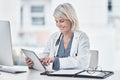 Medical news you can use. a mature doctor using a digital tablet at work. Royalty Free Stock Photo