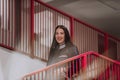 A medical nurse descends the stairs of a modern hospital, showcasing her professionalism, efficiency, and dedication to