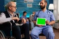 Elderly man looking at green screen tablet held by nurse Royalty Free Stock Photo