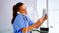 Medical nurse holding patient x-ray in hospital while talking on phone Royalty Free Stock Photo