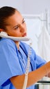 Medical nurse holding patient x-ray in hospital while talking on phone Royalty Free Stock Photo