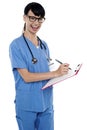Medical nurse jotting down notes on writing pad Royalty Free Stock Photo