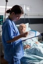 Medical nurse in scrubs taking notest on cliboard Royalty Free Stock Photo