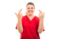 Medical nurse wearing red scrub showing double cross fingers gesture.