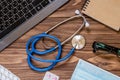 Stethoscope macro view on the wooden desktop. Other medical and office objects on the table Royalty Free Stock Photo