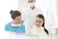 Dentist with assistant explaining procedure to patient at dental clinic Royalty Free Stock Photo