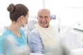 Female dentist talking to smiling senior patient at dental clinic Royalty Free Stock Photo