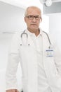 Portrait of confident senior doctor in labcoat standing at hospital