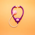 Medical phonendoscope stethoscope on orange background