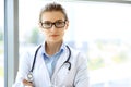 Medical physician doctor woman over blue clinic background. Royalty Free Stock Photo