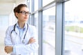 Medical physician doctor woman over blue clinic background. Royalty Free Stock Photo