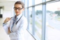 Medical physician doctor woman over blue clinic background. Royalty Free Stock Photo