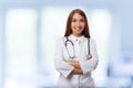 Medical physician doctor woman over blue clinic background. Royalty Free Stock Photo