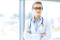 Medical physician doctor woman over blue clinic background. Royalty Free Stock Photo