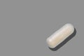 Medical pill, pharmaceutical medicine capsule. Painkiller, vitamin, antibiotic, probiotic on grey background Royalty Free Stock Photo