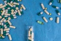 Medical pills, capsules, tablets spilling out from bottle on blue background Royalty Free Stock Photo