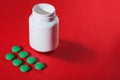 Medical pills on a colored background with a white vial