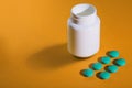 Medical pills on a colored background with a white vial