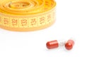 Medical pills for dieting in front of measuring tape Royalty Free Stock Photo