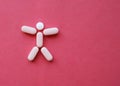 Medical pills in the shape of a man on a red background Royalty Free Stock Photo