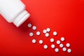 Medical pills spilling out of bottle. On red background. Top vie Royalty Free Stock Photo