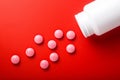 Medical pills spilling out of bottle. On red background. Top vie Royalty Free Stock Photo