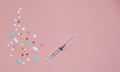 Medical pink background, syringe and many different pills Royalty Free Stock Photo