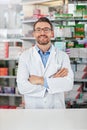 Medical, portrait and male pharmacist with crossed arms for confidence standing in a pharmacy clinic. Pharmaceutical