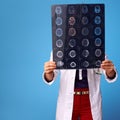 Medical practitioner woman looking at tomography on blue Royalty Free Stock Photo