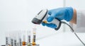 Close-up of a Medical Professional Scanning Sample Barcode in a Lab with Blue Gloves and White Coat Against a Clean White Royalty Free Stock Photo