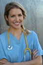 Medical professionals: Woman nurse smiling while working at hospital. Young beautiful blond caucasian female health care worker Royalty Free Stock Photo