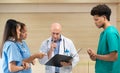 A medical professor gives advice on patient examinations to medical students practicing